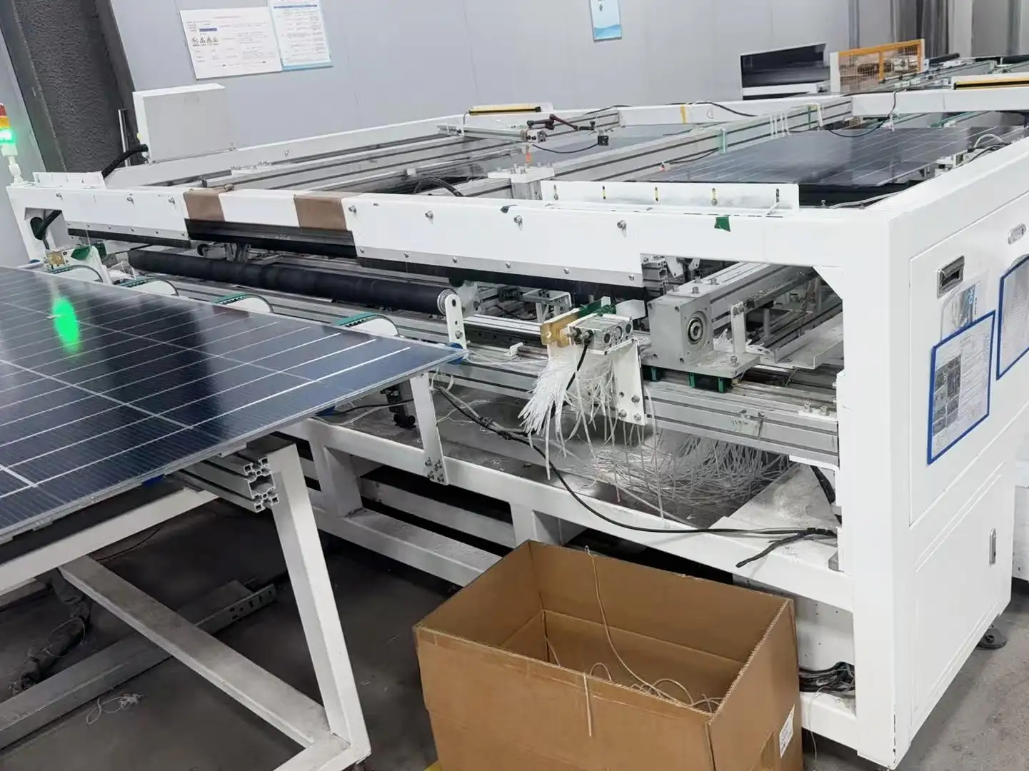 Trimming machine to remove excess film after solar panel lamination