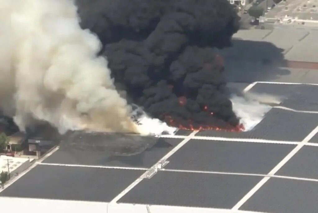 Closeup of rooftop solar panel array on fire, DC arc ignition at Lineage cold storage